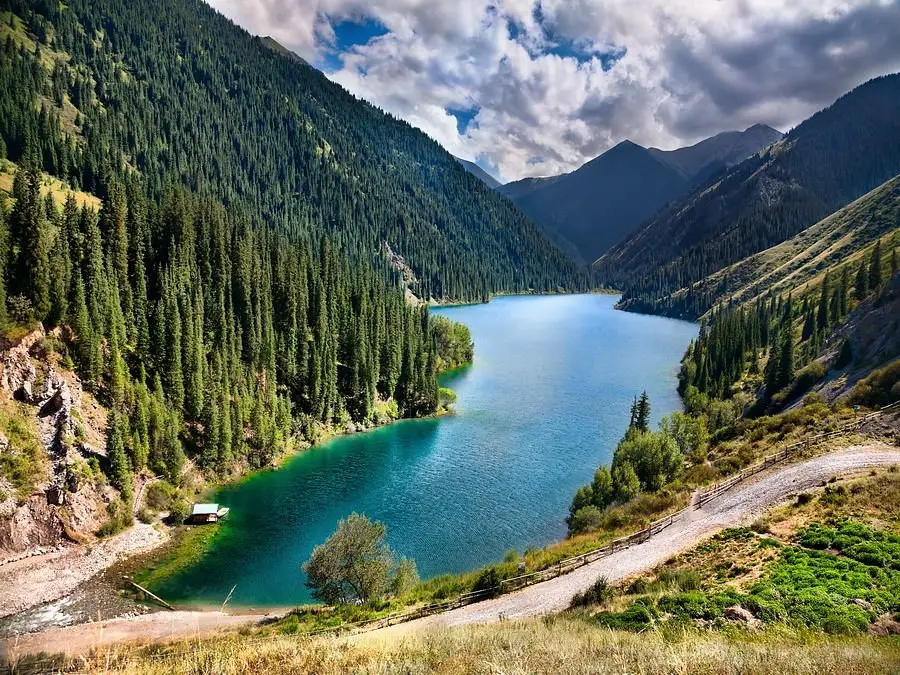 Turquoise mountain lake among spruce forests in Kazakhstan