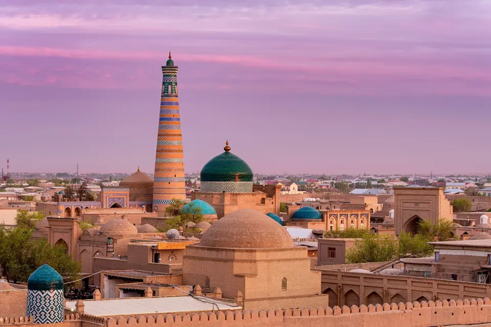Islam Khoja minaret and the domes of Khiva at dusk